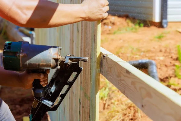 using-an-air-nail-gun-a-man-constructs-portions-o-2026-03-24-23-45-04-utc